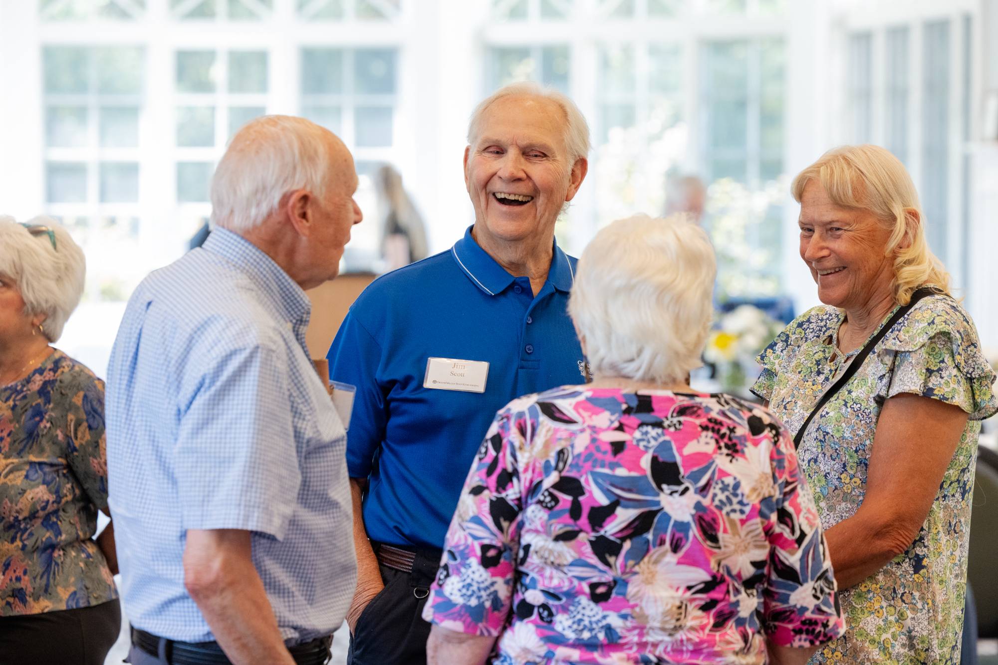 Four retirees talking together and enjoying event